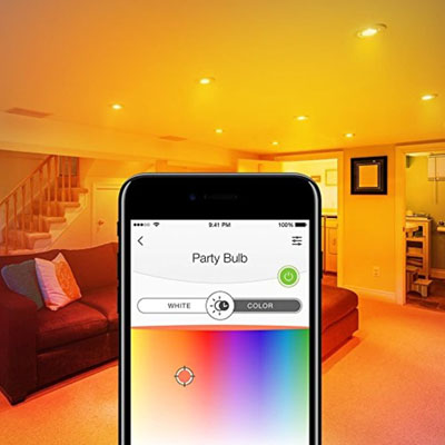 Black smartphone with a color slider in front of an orange-lit living room